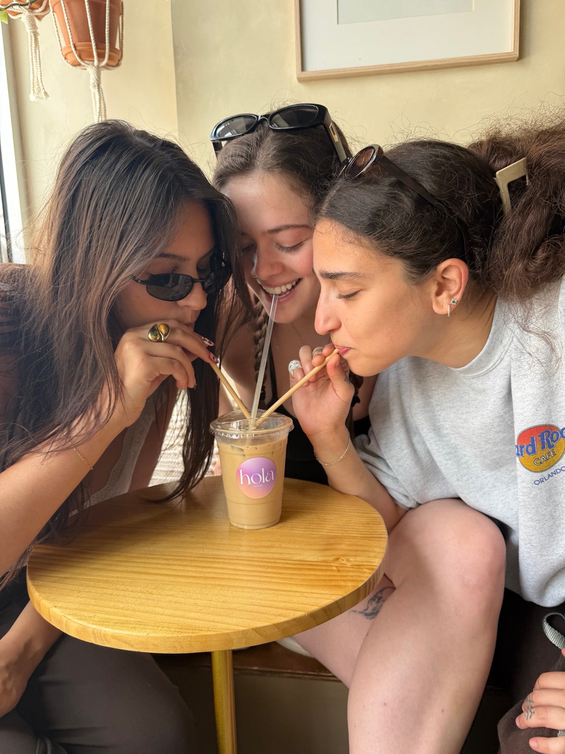 Three friends sharing a Hola iced coffee inside the café